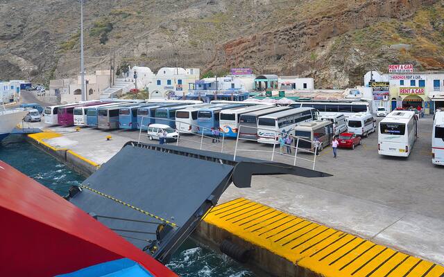 Bussen wachten op passagiers bij de haven van Athinios op Santorini