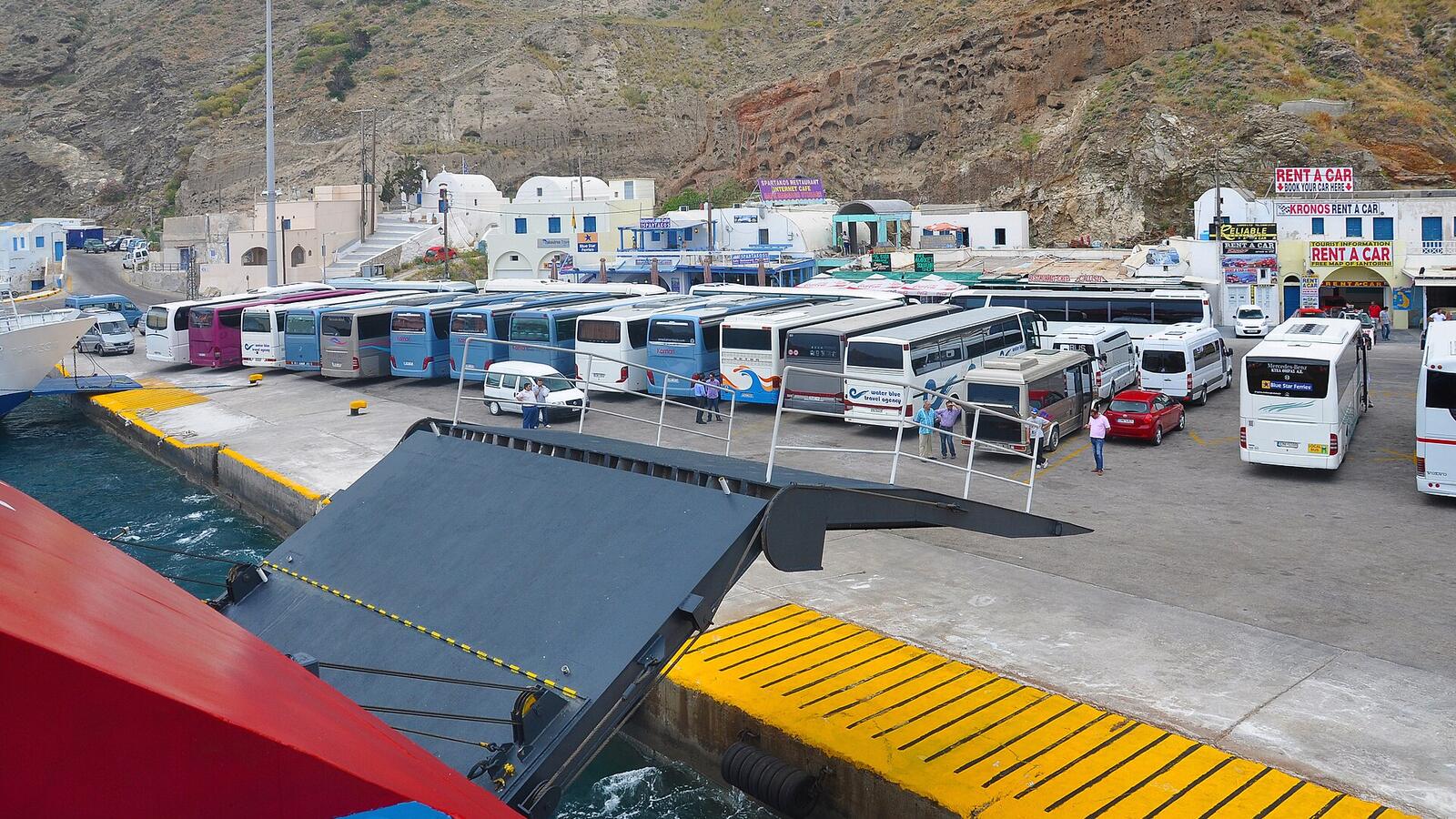 Bussen wachten op passagiers bij de haven van Athinios op Santorini