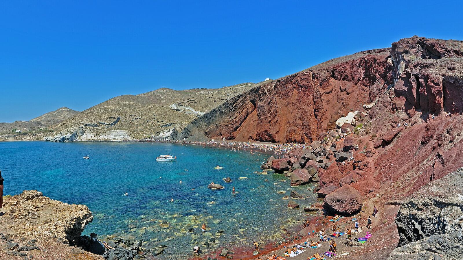 De Red Beach bij Akrotiri met rode kliffen, zwarte kiezels en helderblauw water