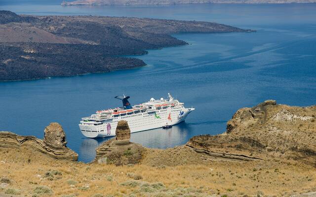 Een cruiseschip in de caldera van Santorini onder de kliffen