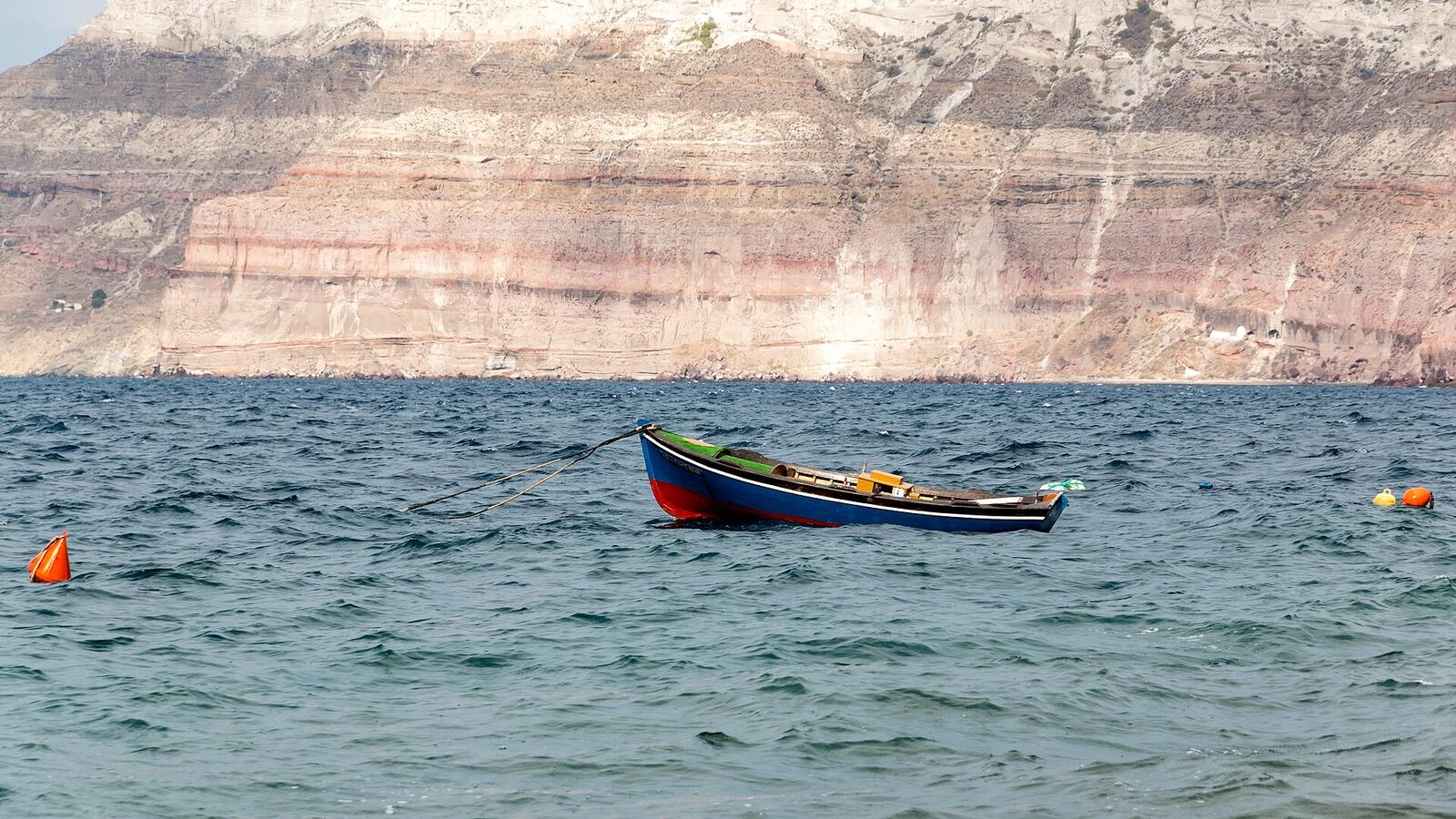 Bootjes in de caldera bij Akrotiri met de steile calderawand