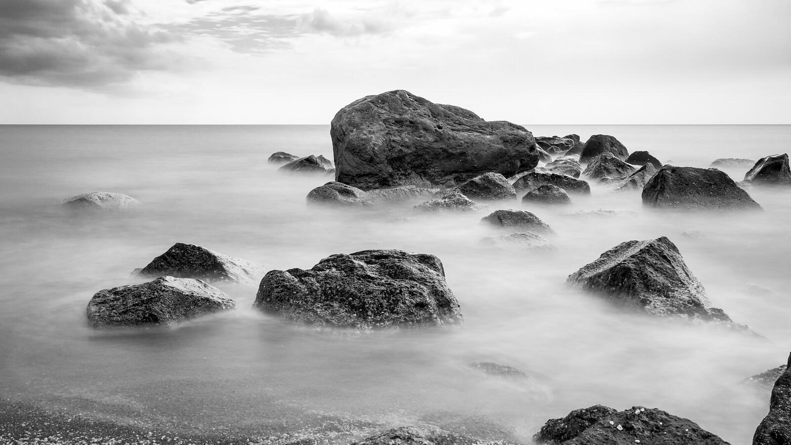 Zwart-witfoto van rotsen in de zee bij Vlychada Beach